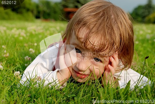 Image of Close-up little girl on the green grass outdoor