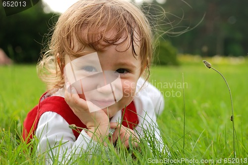 Image of Close-up little girl on the green grass outdoor