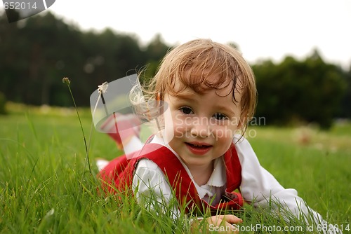 Image of Close-up little girl on the green grass outdoor