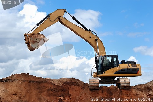 Image of excavator with raised bucket