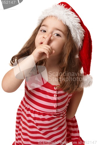 Image of Little girl in santa hat gesturing peace and quiet