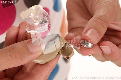 Image of hearing aid and battery