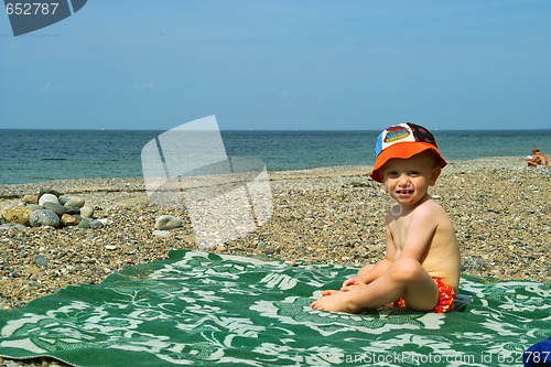 Image of The boy sits on seacoast