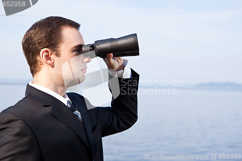 Image of Caucasian businessman with binoculars