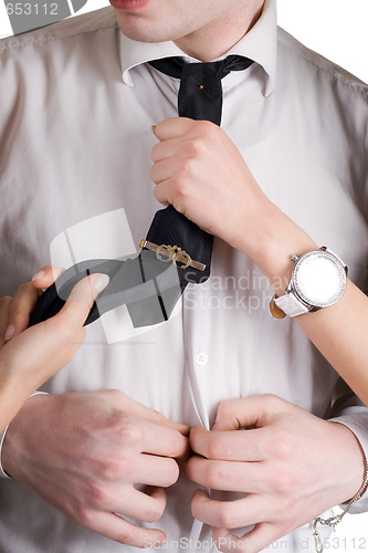 Image of Young man, a tie and female hands. Isolated