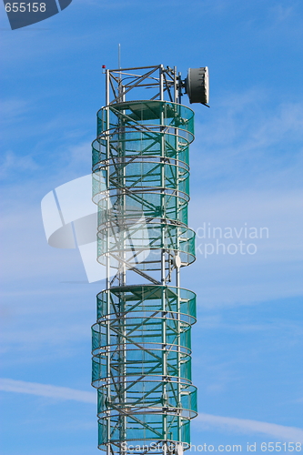 Image of Telecommunications mast set against blue sky and small clouds
