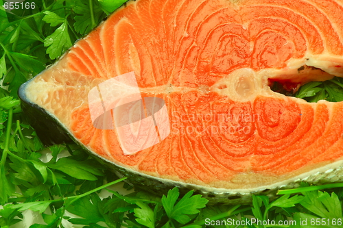 Image of Fresh salmon steak on the salad leaf