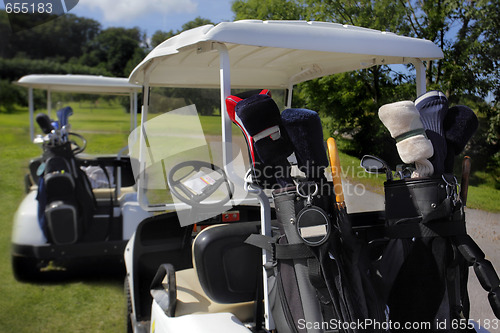 Image of Two golf cart with clubs ready to go