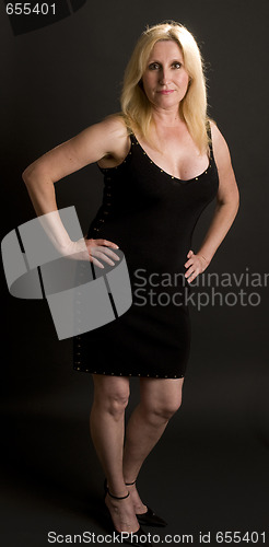 Image of glamorous middle age woman posing in black dress