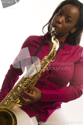 Image of young hispanic black woman playing tenor saxophone