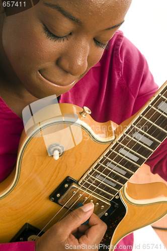 Image of young hispanic black woman playing electric guitar