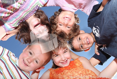 Image of Five Friends Outdoors Looking Down Smiling