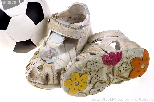 Image of Baby football shoes and ball on white background