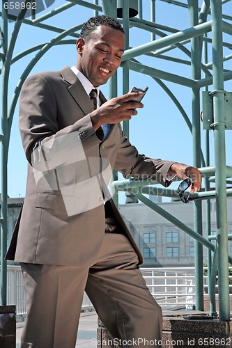 Image of Business Man Checking His Mobile Phone Smiling