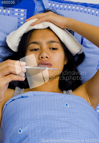 Image of pretty young woman sick in bed