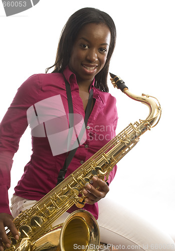 Image of young african american girl playing saxophone music