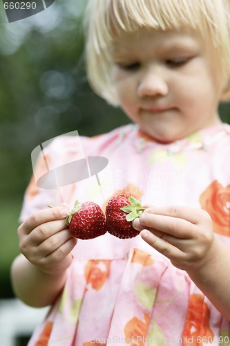 Image of Girl holding two strawberries.