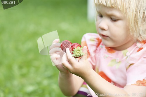 Image of Girl holding two strawberries.