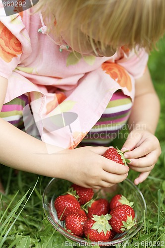 Image of Little girl holding strawberry.