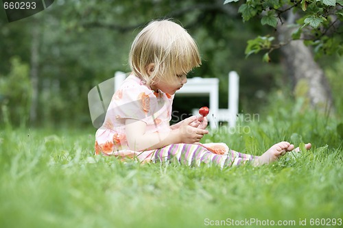 Image of Girl holding a strawberry.