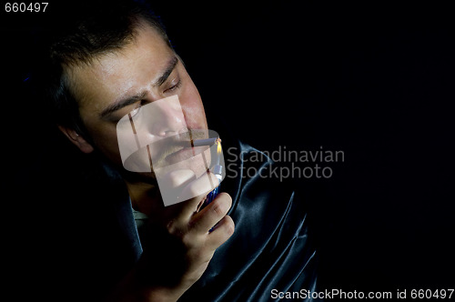 Image of man is lighting a cigarette