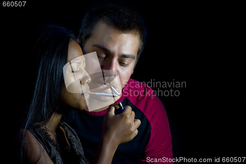 Image of couple is lighting their cigarettes