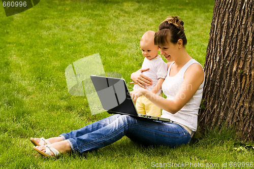 Image of Happy family with notebook on the grass