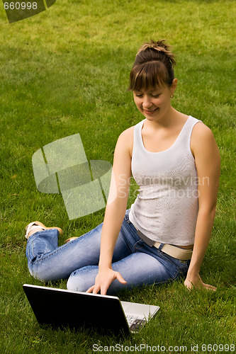 Image of Young woman with notebook on the grass