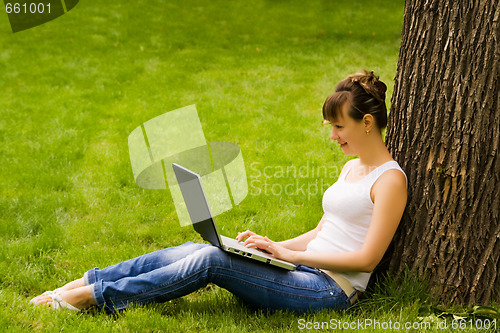 Image of Young woman on the grass with notebook