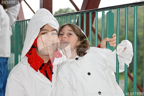 Image of Mother and daughter in white hooded cloaks 