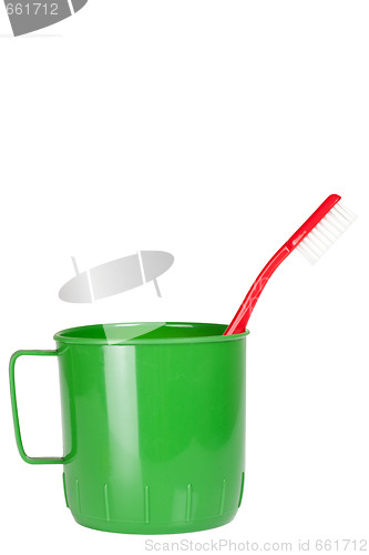 Image of Green plastic mug with toothbrush