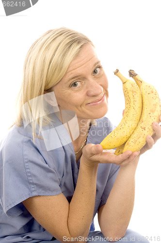 Image of smiling happy nurse doctor with healthy fresh bunch ripe bananas