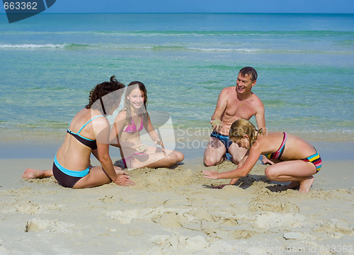 Image of happy family playing at the beach