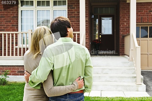 Image of Happy couple in front of home