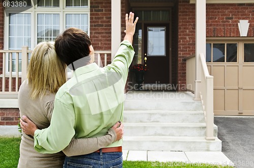Image of Happy couple in front of home