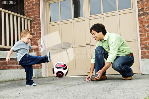 Image of Father and son playing soccer