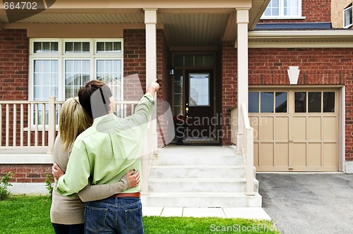 Image of Happy couple in front of home