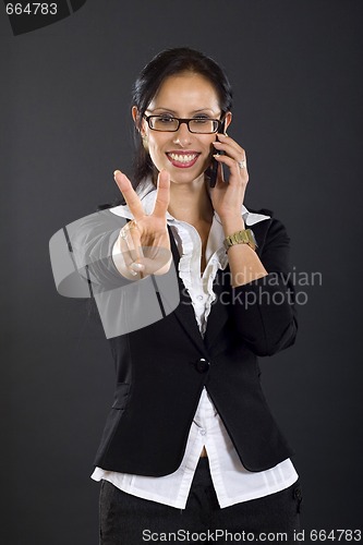 Image of picture of an attractive businesswoman on the phone making her ok sign