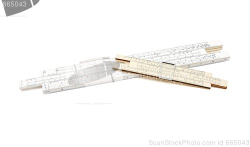 Image of Two crossed vintage slide rule mechanical calculators isolated