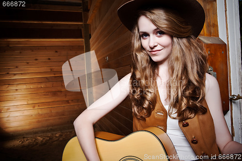 Image of Beautiful caucasian cowgirl with guitar