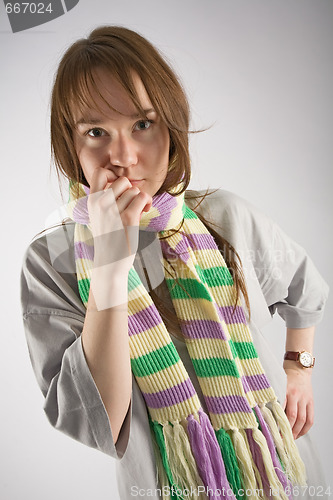 Image of thoughtful young woman in striped muffler