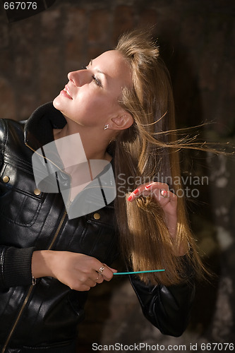 Image of beautiful girl combs long hairs