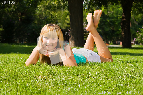 Image of Young smiling girl lies on grass