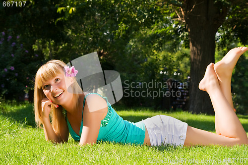Image of Young smiling girl lies on grass