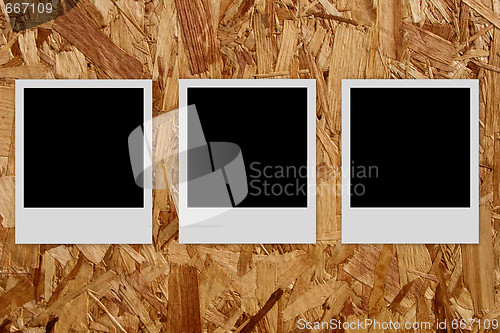 Image of Three empty photo frames  on wood background