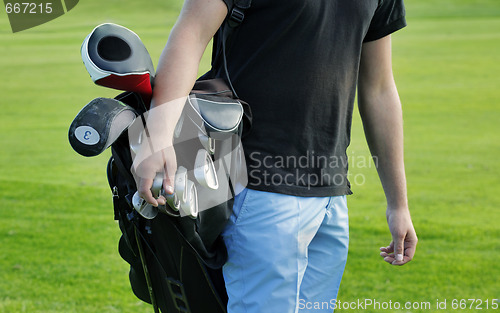Image of Male golfer carrying clubs, close-up