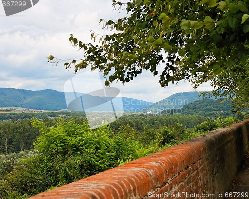 Image of View of green valley over the orange brick wall