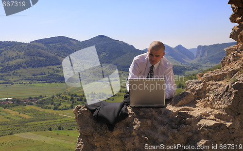 Image of Businessman on a computer outdoors