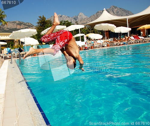 Image of Boy jumping into swimming pool