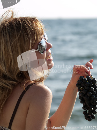 Image of Woman with grape on beach